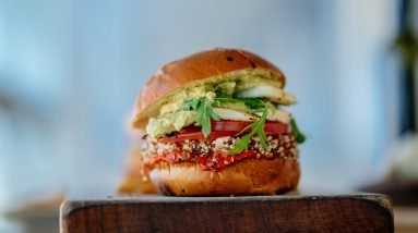 selective focus photography of hamburger with sliced tomatoes and vegetables